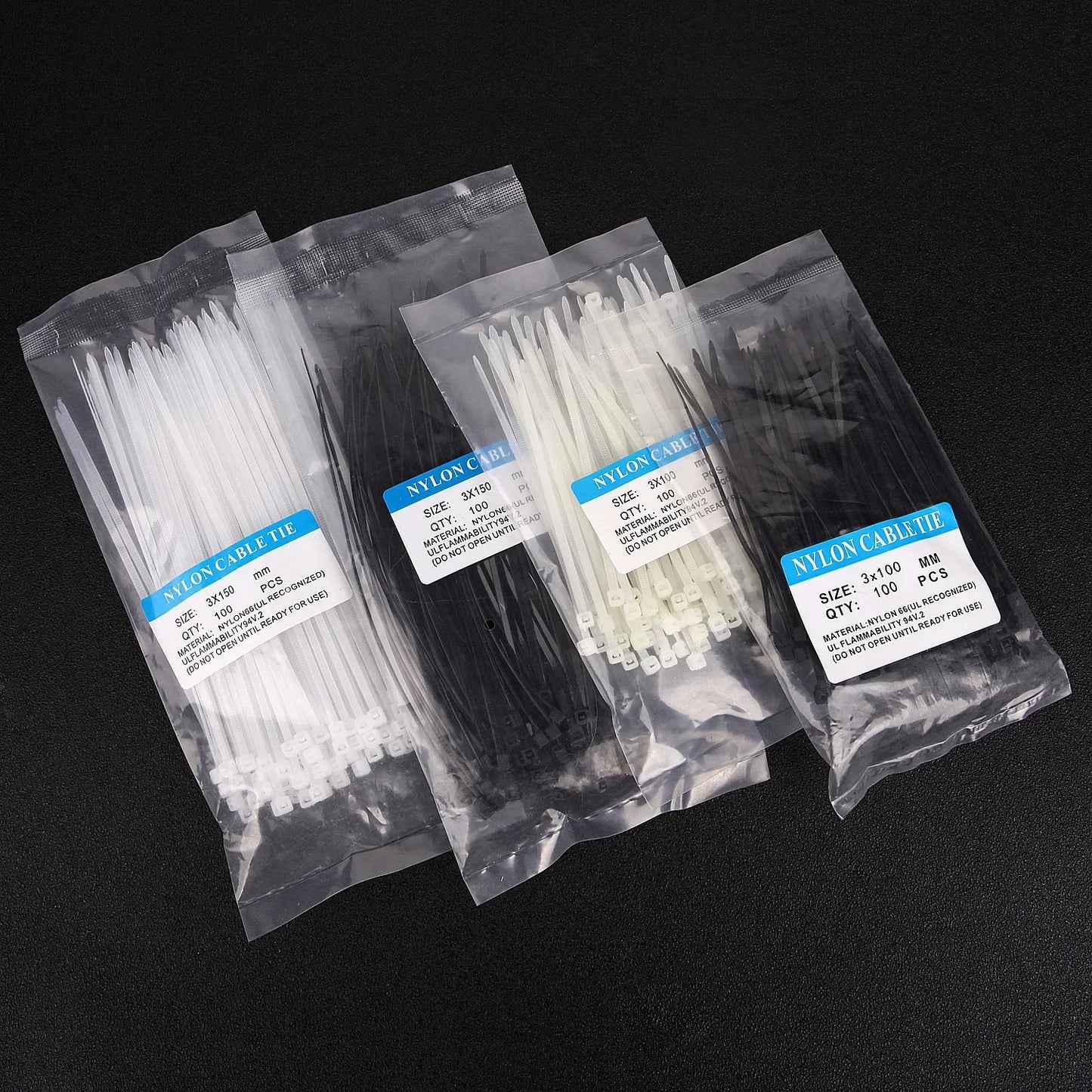 Bolsas de bridas de nylon blancas y negras para organizar cables sobre fondo negro.