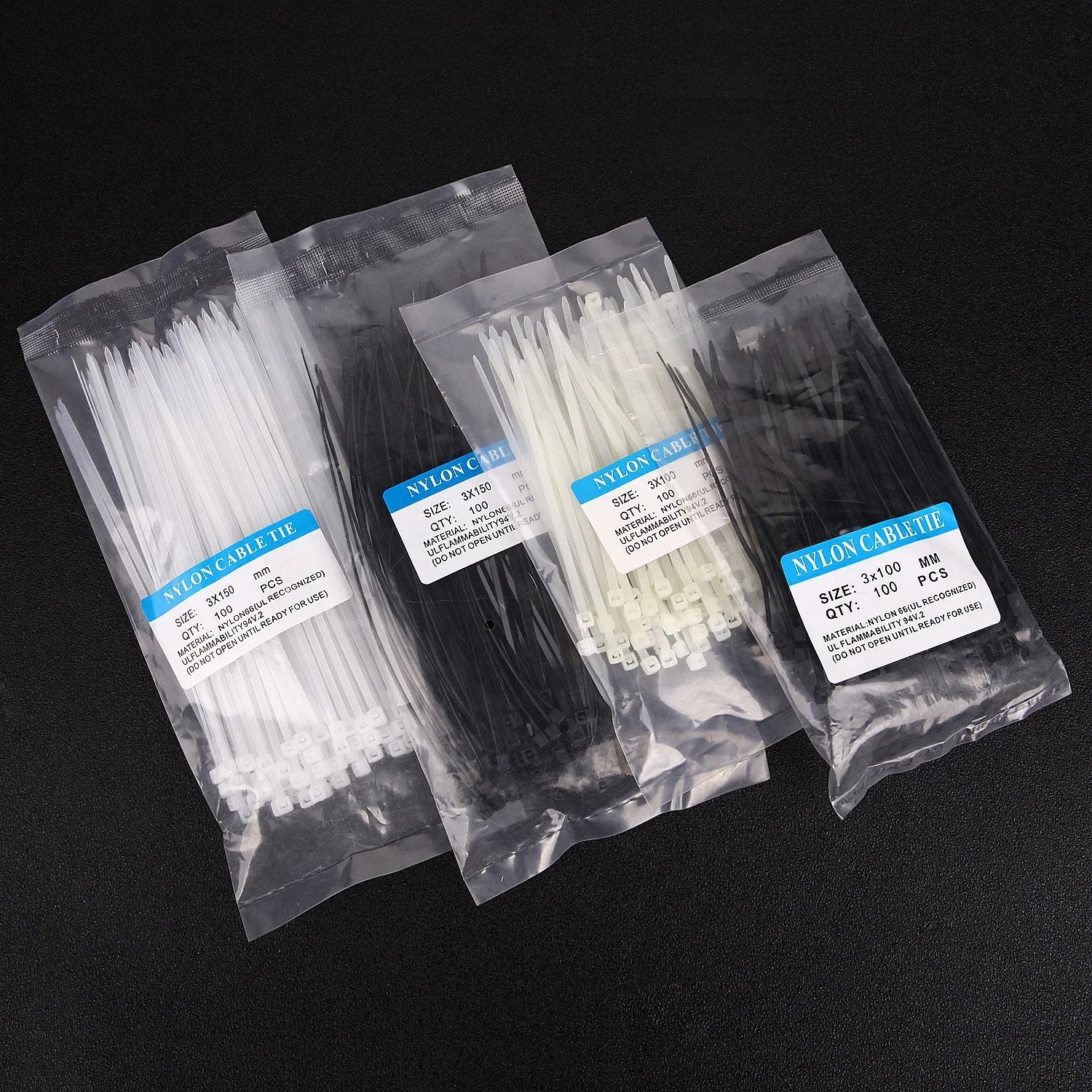 Bolsas de bridas de nylon blancas y negras para organizar cables sobre fondo negro.