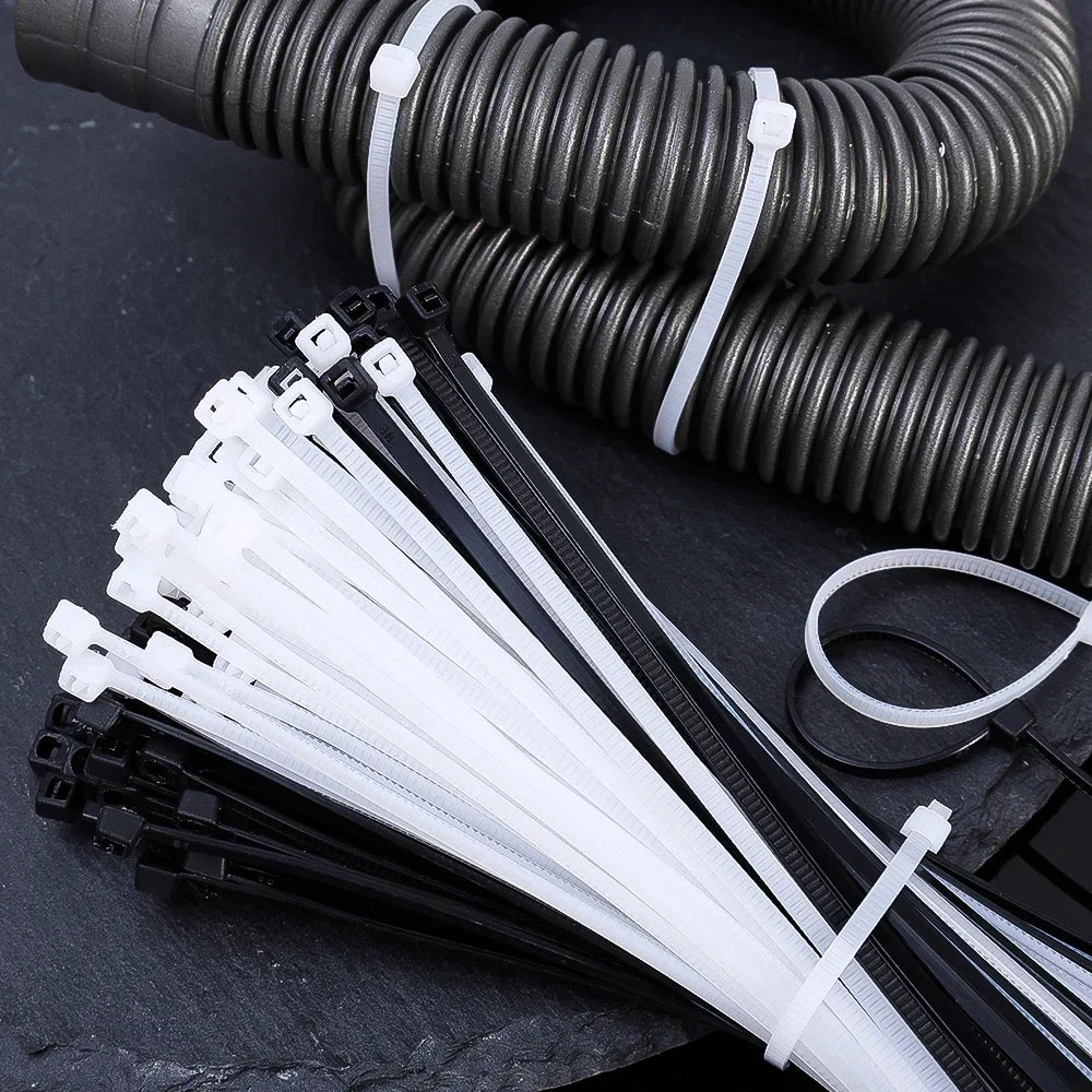 Bridas plásticas blancas y negras para organización de cables o tuberías