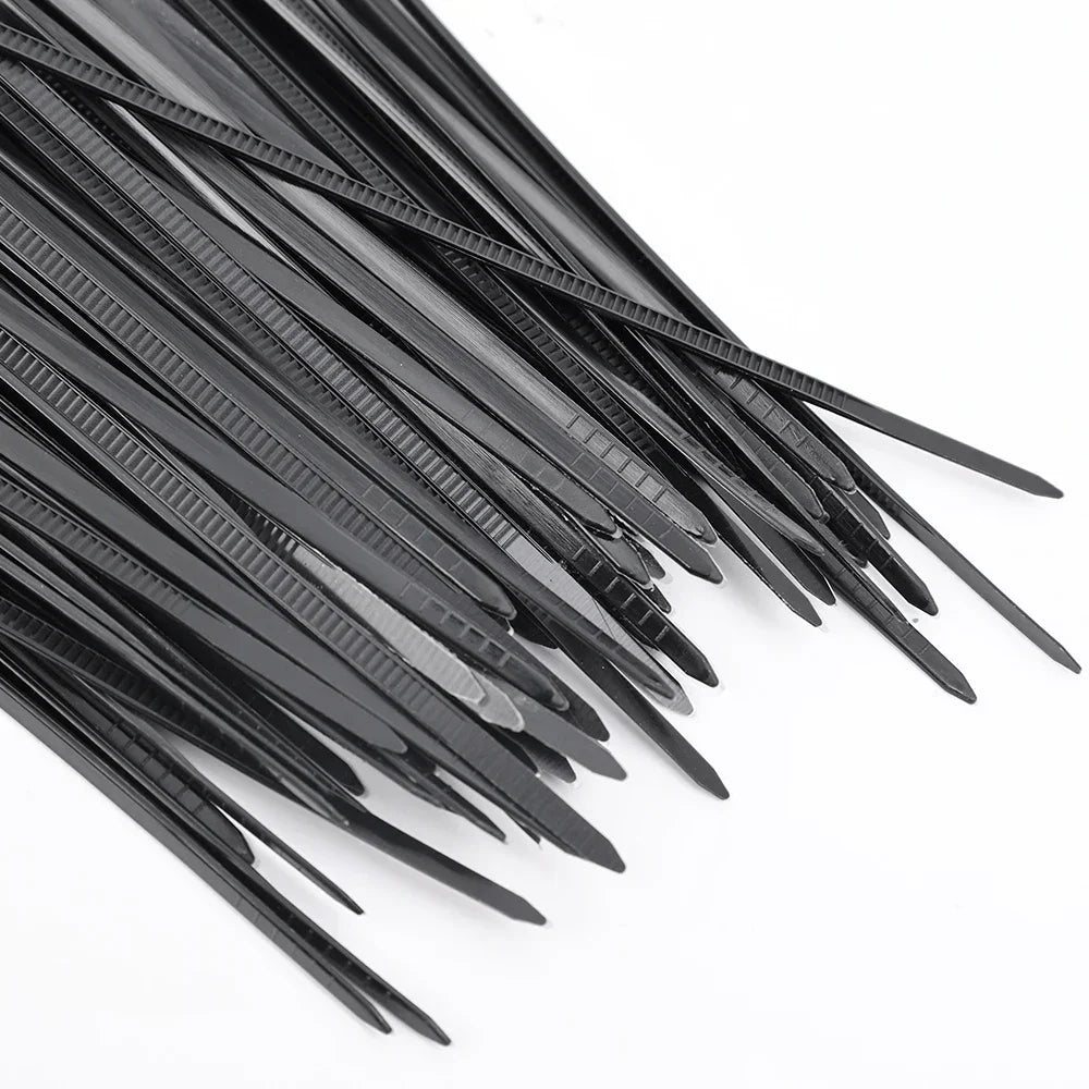 Bridas de plástico negras para organizar cables en superficie blanca