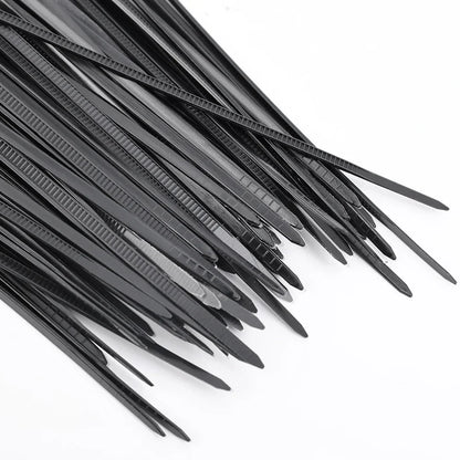 Bridas de plástico negras para organizar cables en superficie blanca