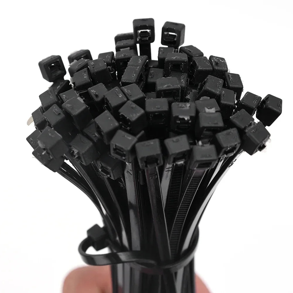 Manojo de bridas plásticas negras para organizar cables en fondo blanco
